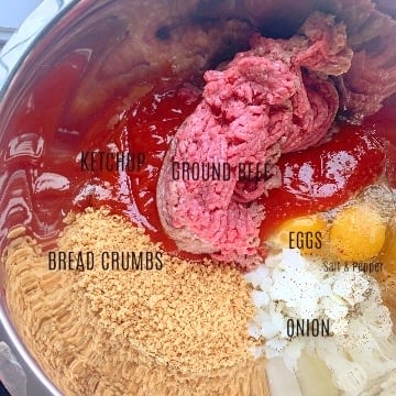 Raw meatloaf ingredients in a mixing bowl with each ingredient labeled