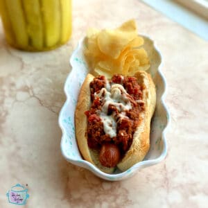 Side view of a hot dog covered in slow cooker hot dog chili