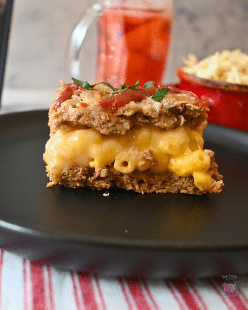 a side view of a slice of mac and cheese stuffed slow cooker meatloaf