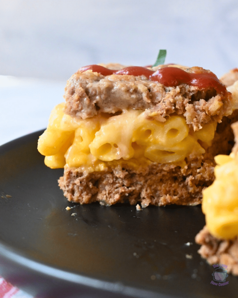 a side view of a slice of mac and cheese stuffed slow cooker meatloaf