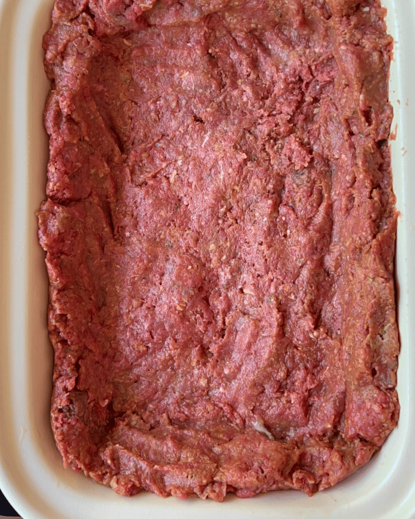 ground beef mixture lining a slow cooker