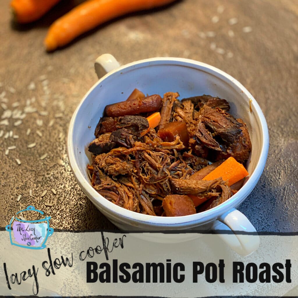 close up of cooked and shredded roast in a round white bowl and some cooked carrots