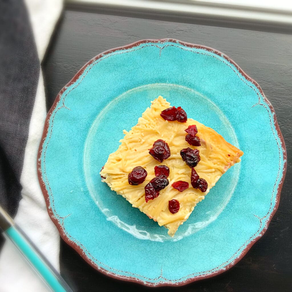 top view of a piece of noodle kugel with craisins on top