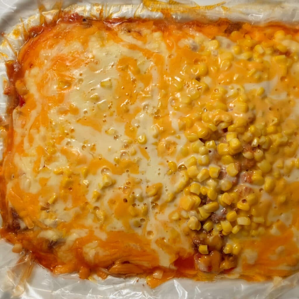 looking down on lasagna in slow cooker right after cooking time is finished.