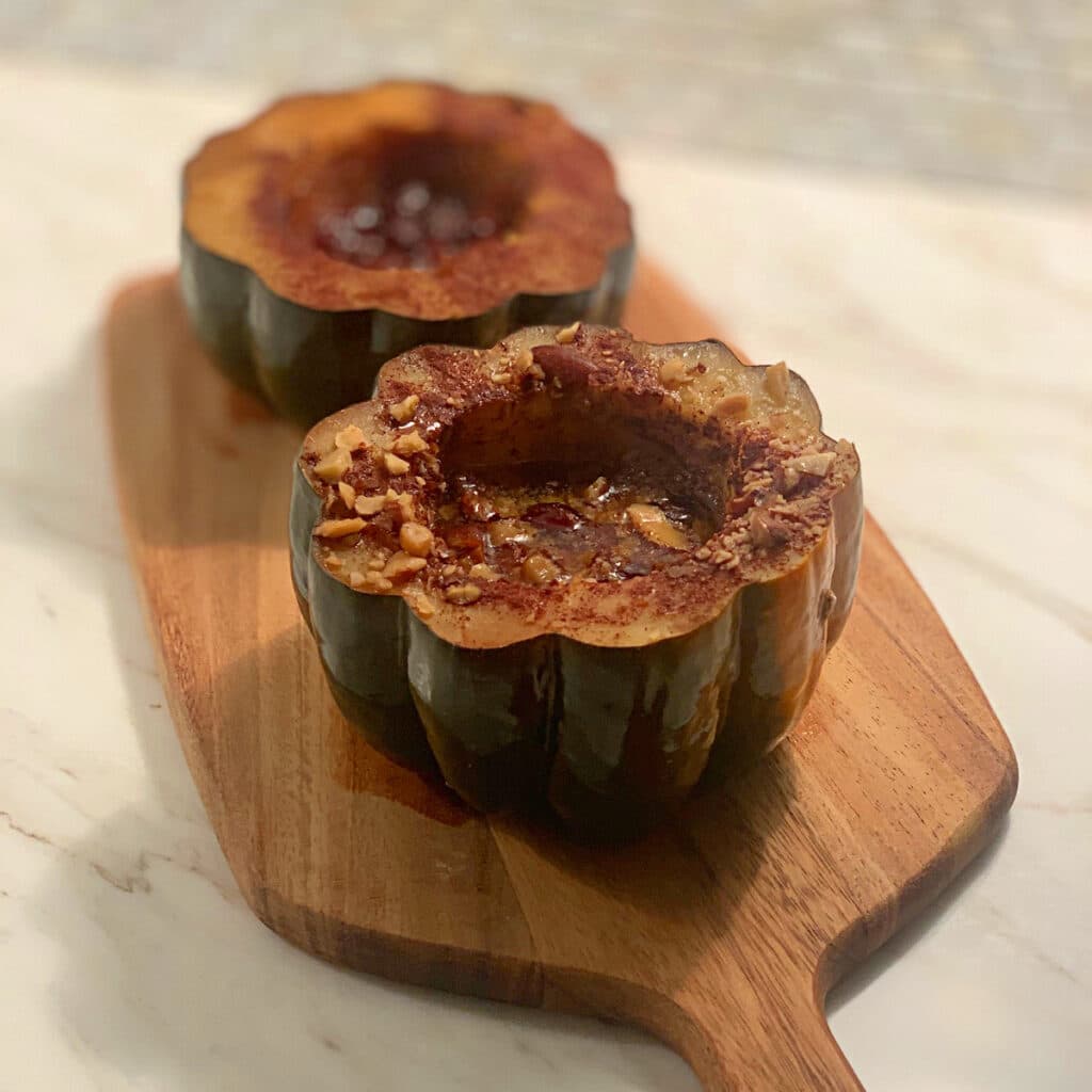 Two finished butternut squash halves on a cutting board ready to be served