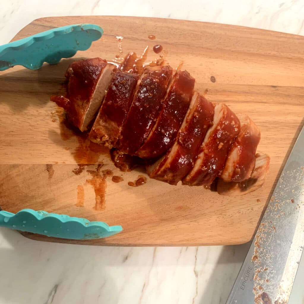 chicken breast sliced on a wooden cutting board