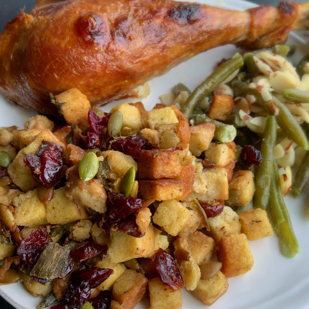 Cranberry stuffing on a plate with a tureky leg and grean beeds