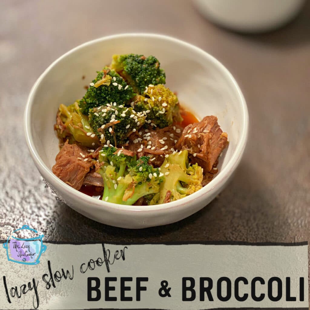 A white round bowl containing cooked beef chunks and bright green cooked cauliflower sprinkled with sesame seeds