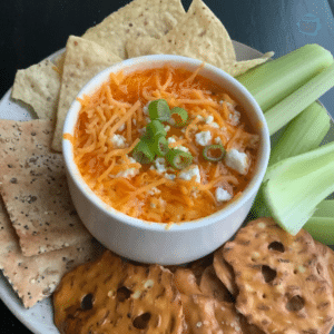 Round white bowl with turkey dip and cheese melted on top