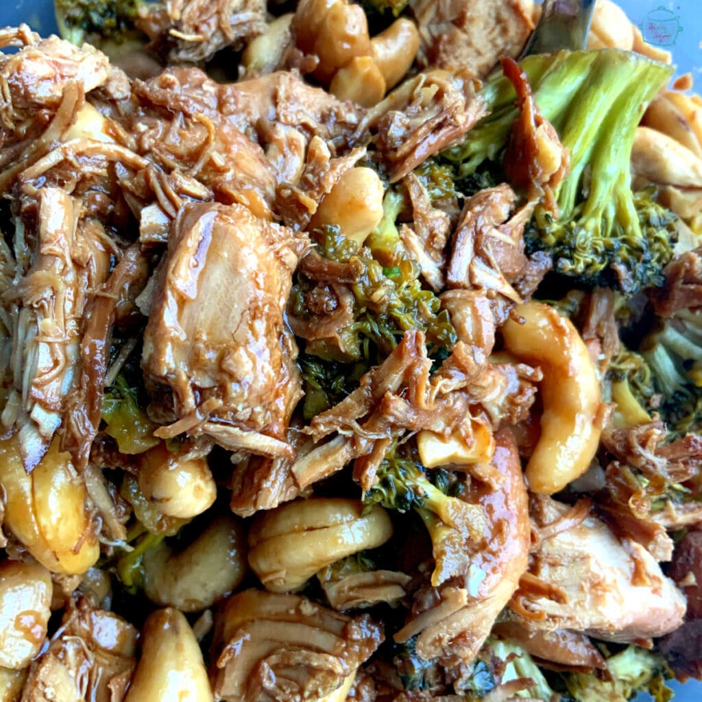 Finished dish up close with shredded of chicken, broccoli and cashews all coated in a wet brown sauce