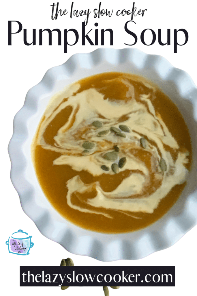 a white bowl filled with pumpkin soup topped with a swirl of coconut cream and some pumpkin seeds.