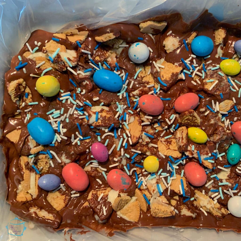 milk chocolate bark in a slow cooker decorated with Easter Eggs and sprinkles