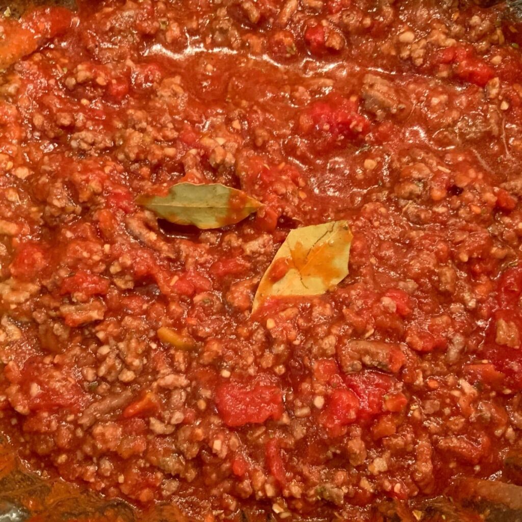 Close up of cooked goulash in slow cooker with bay leaves still in