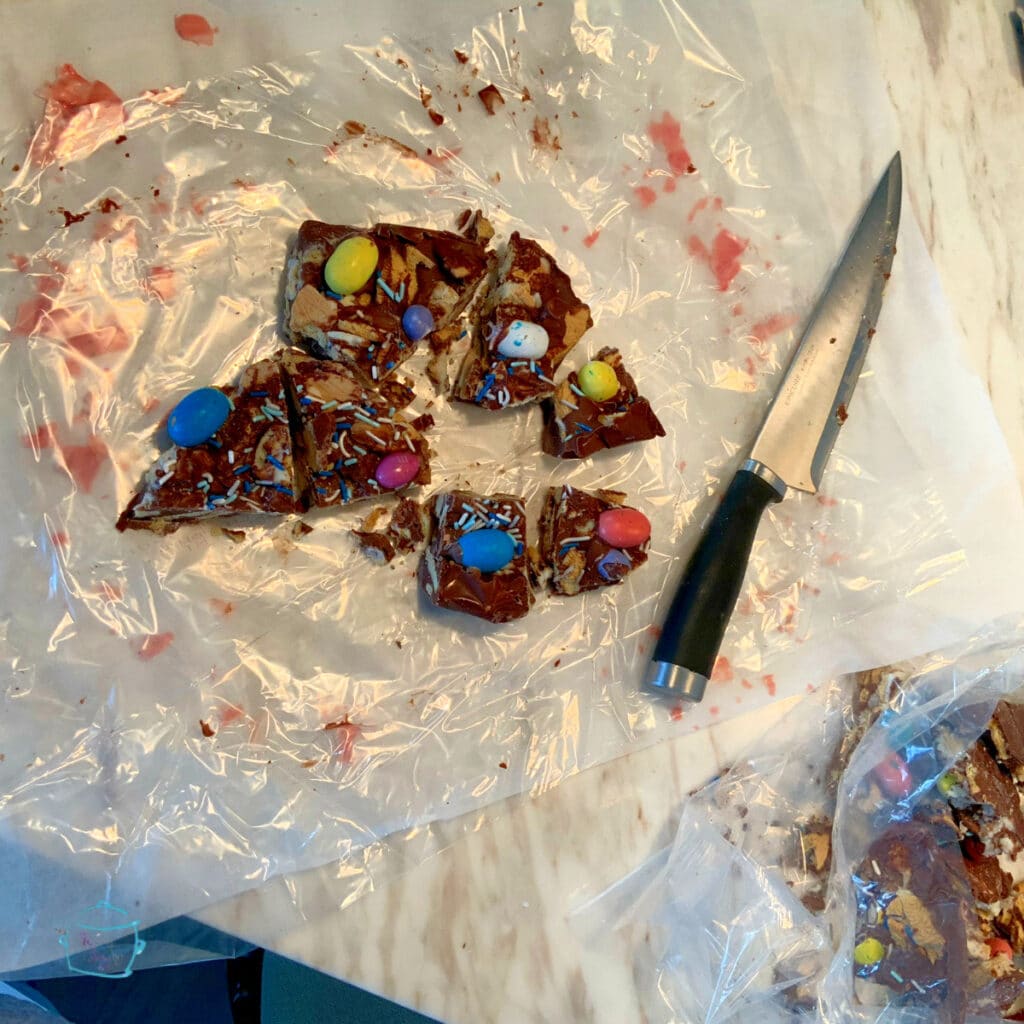 Milk chocolate bark cut into pieces laying next to the knife used to cut them