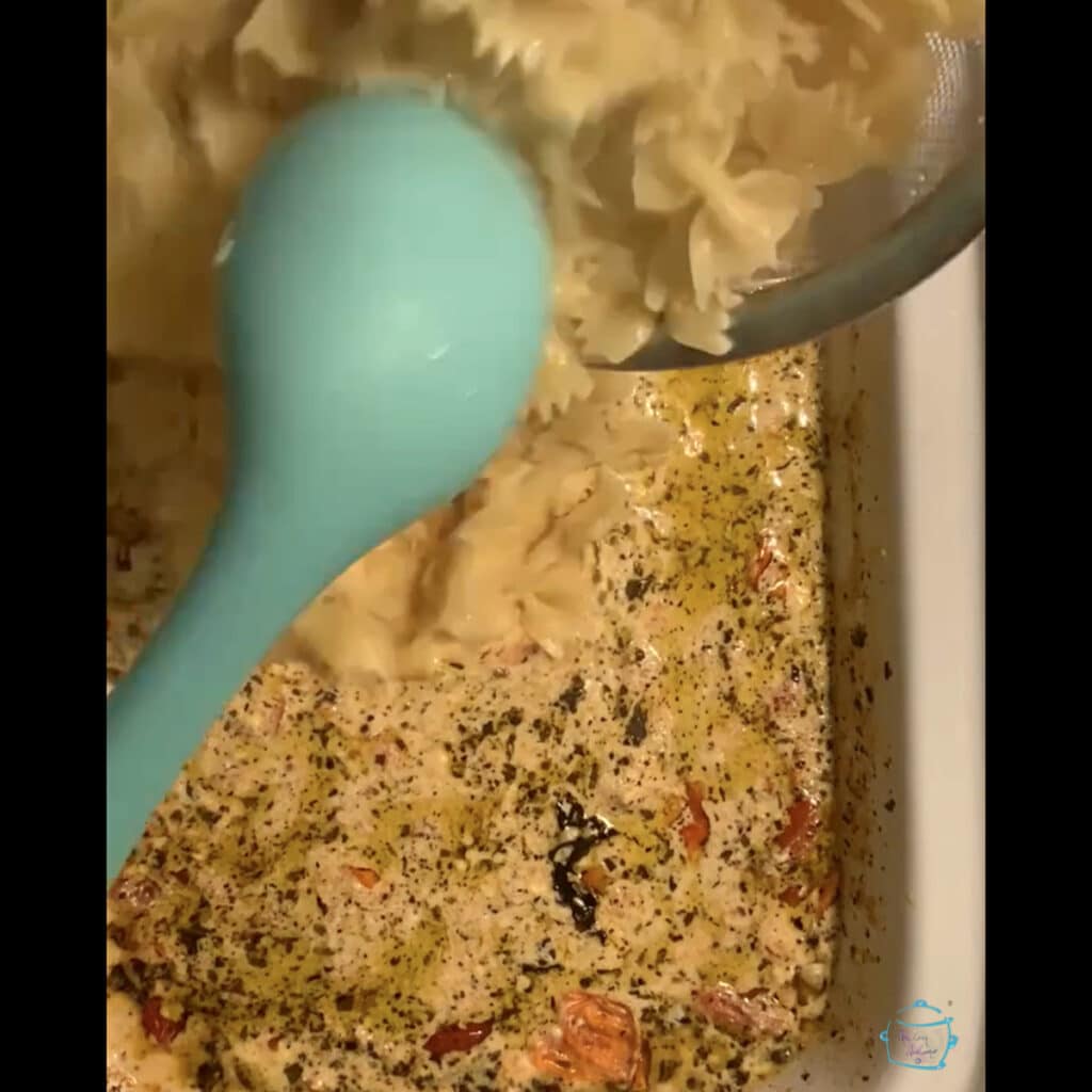 Mixing pasta into sauce