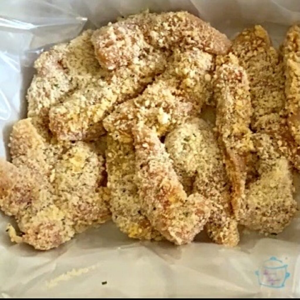 raw breaded chicken tenders in a lined slow cooker