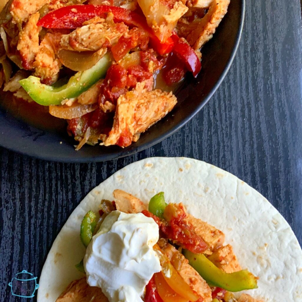 A partial view of a bowl of fajita ingredients next to a tortilla topped with the same