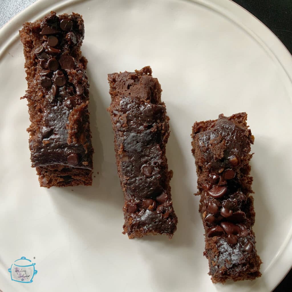 Three pieces of chocolate banana bread in a diagonal line on a plate