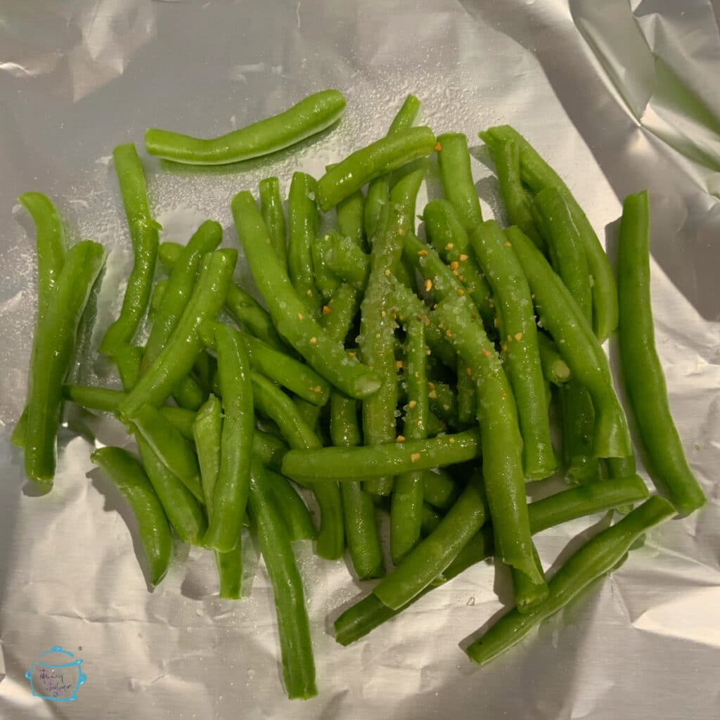 Green beans with garlic salt and oil on a piece of foil