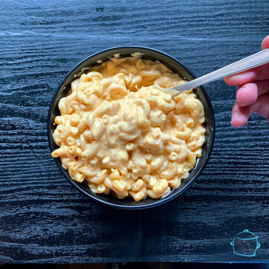 A bowl of macaroni and cheese with a fork in it