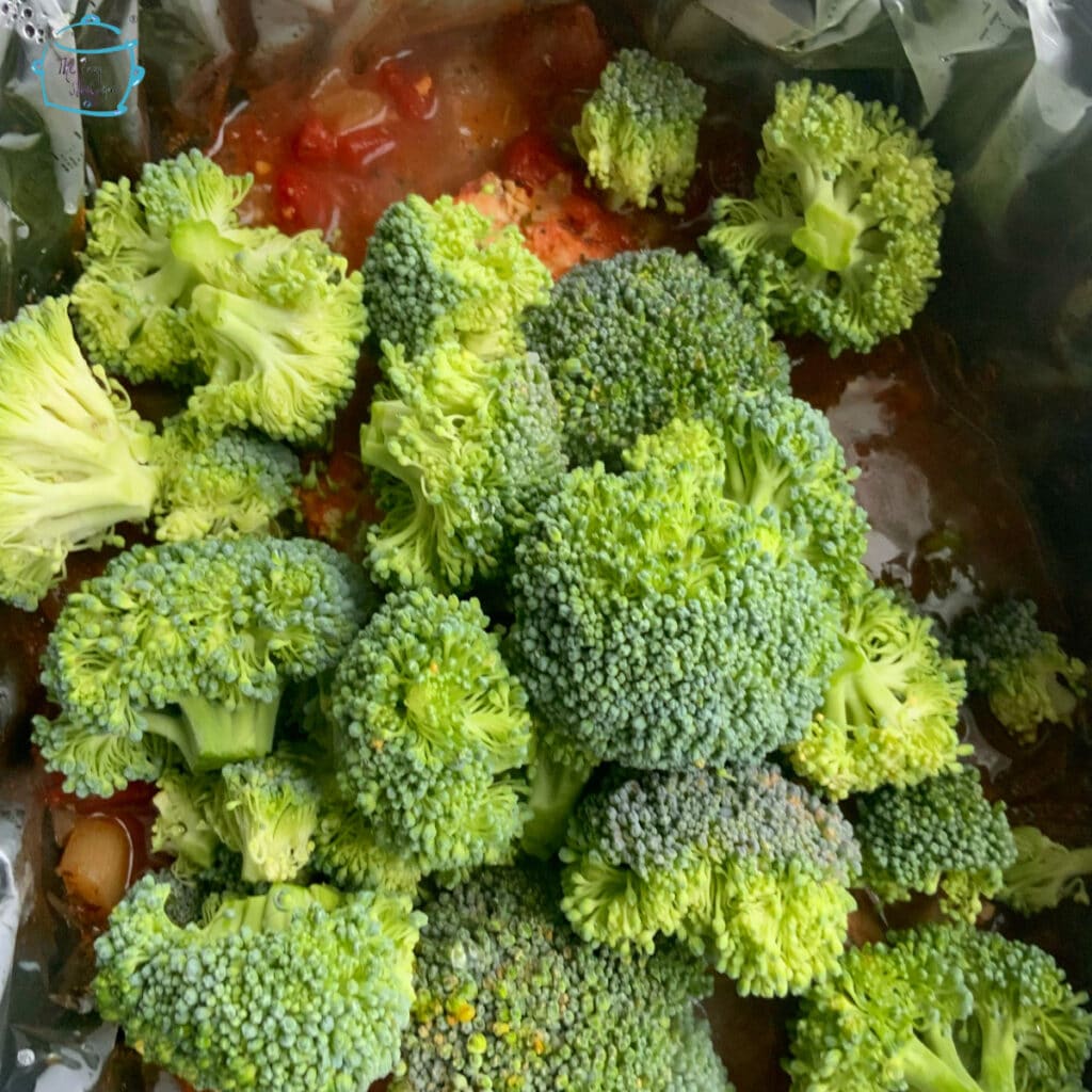 Raw broccoli on top of remaining cooked ingredients