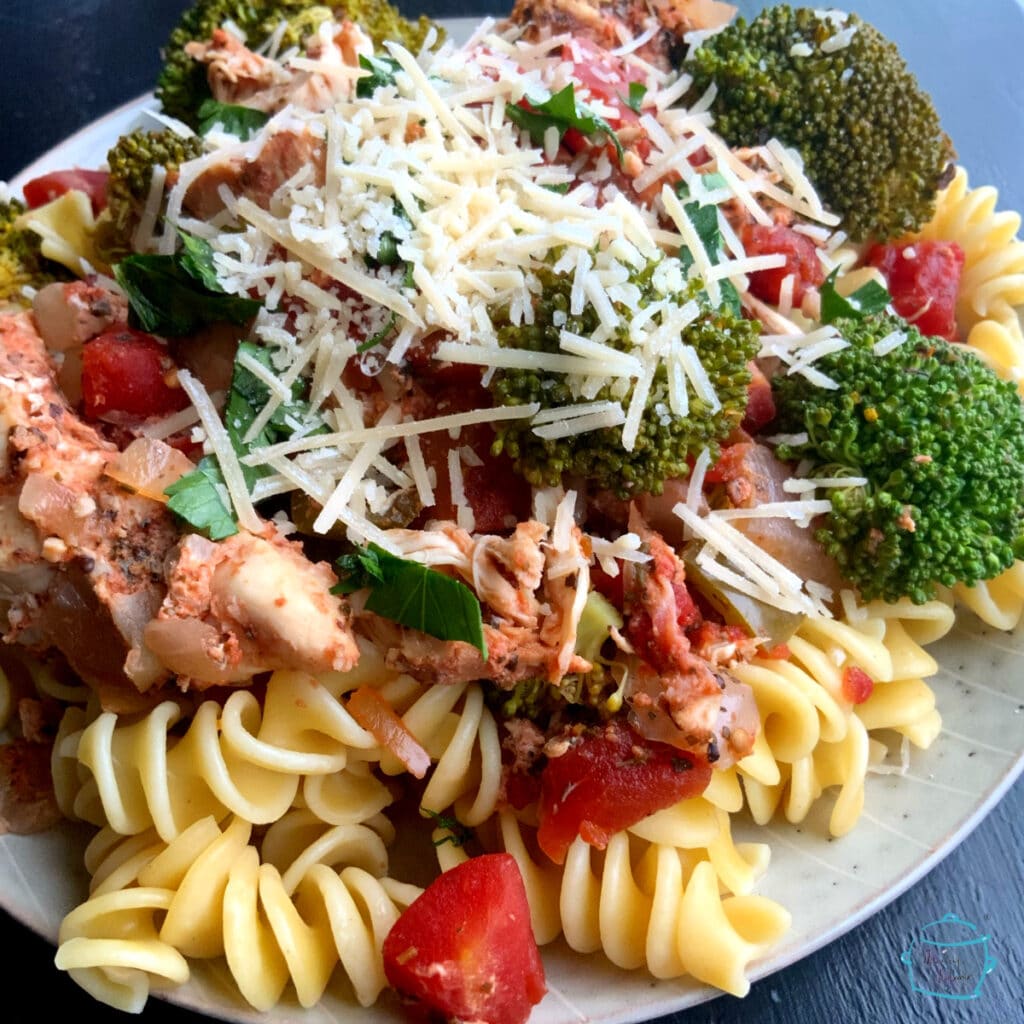 Finished dish plated on pasta topped with parmesan