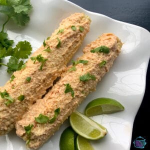 finished corn cobs on a tray with lime wedges a great barbecue side