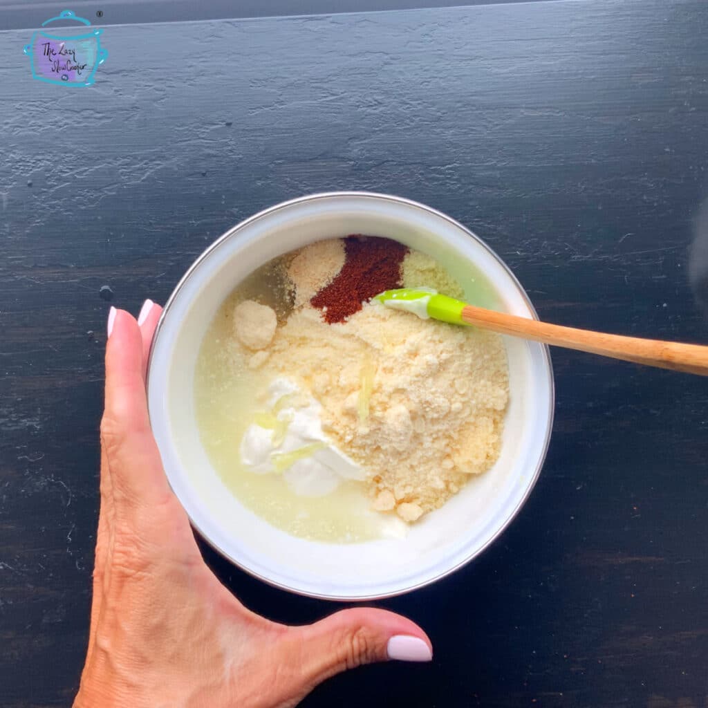 mixing elote dressing togetther in a bolw