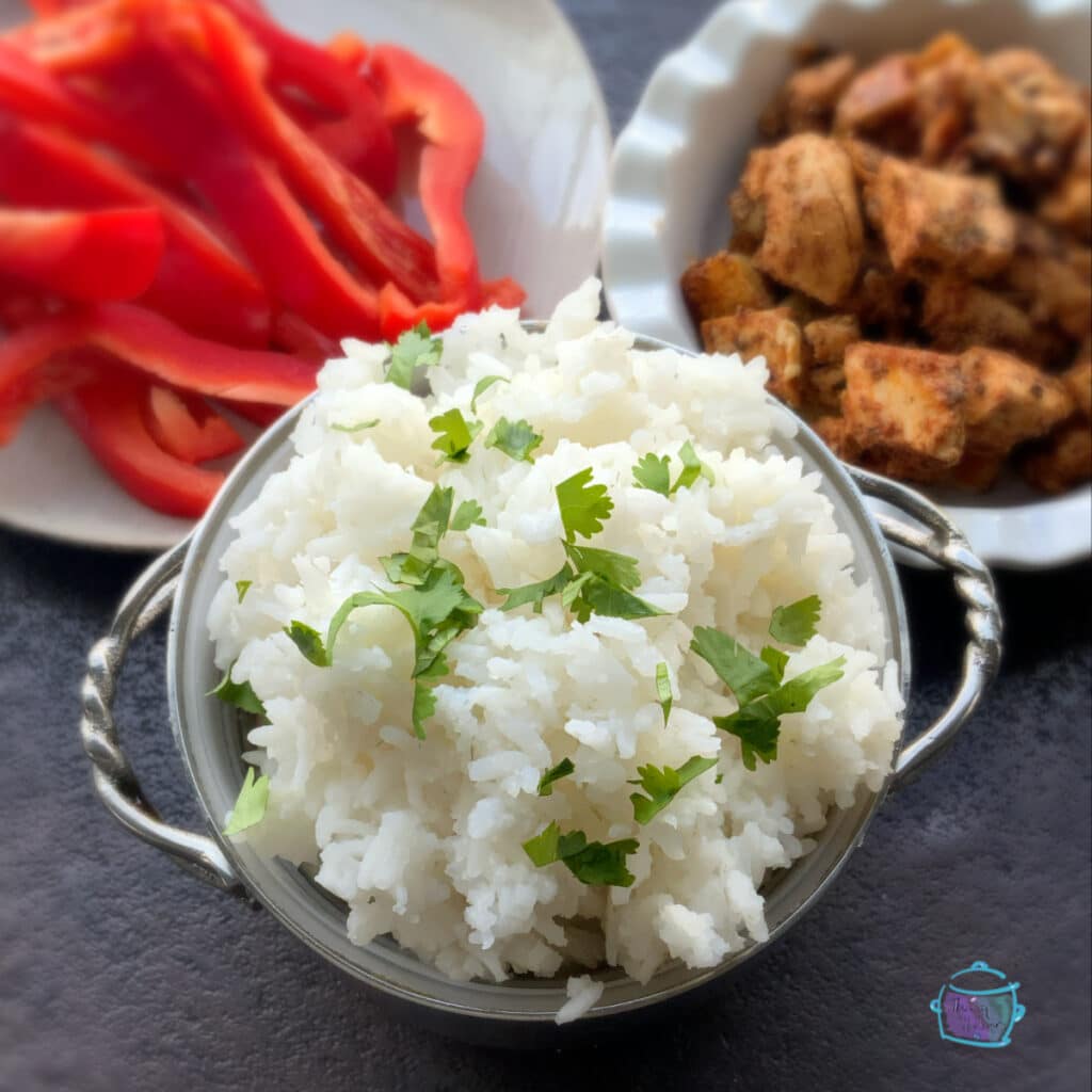 rice with chicken chunks and peppers on side.