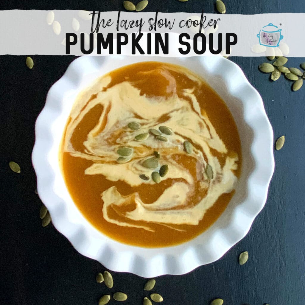 a white bowl with pumpkin soup and some dairy free cream in swirling pattern