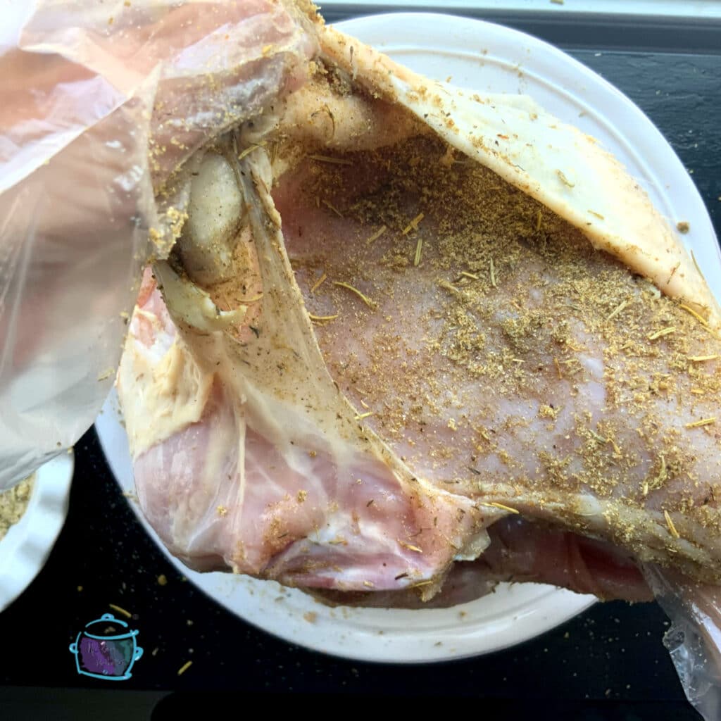 a view of raw bone in turkey breast with spice rub under the skin