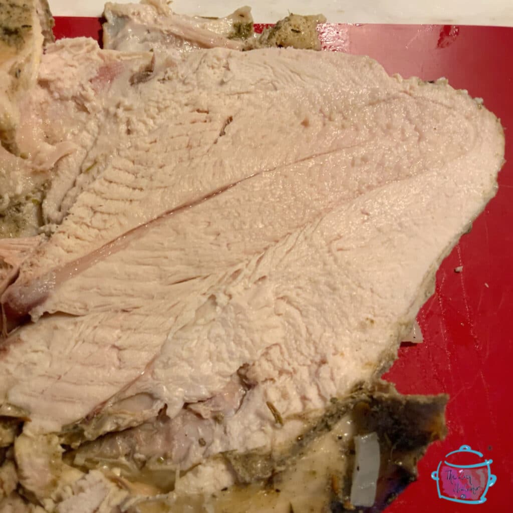 top view of juicy bone-in turkey breast mid way through slicing