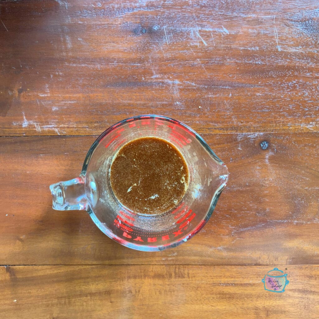 Looking down on a glass measuring cup with glaze mixture