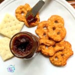 Apple butter with being spread on pretzel flats with other crackers