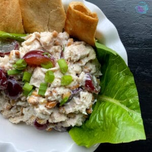 Close up of turkey salad on a lettuce leaf with pita chips on the side