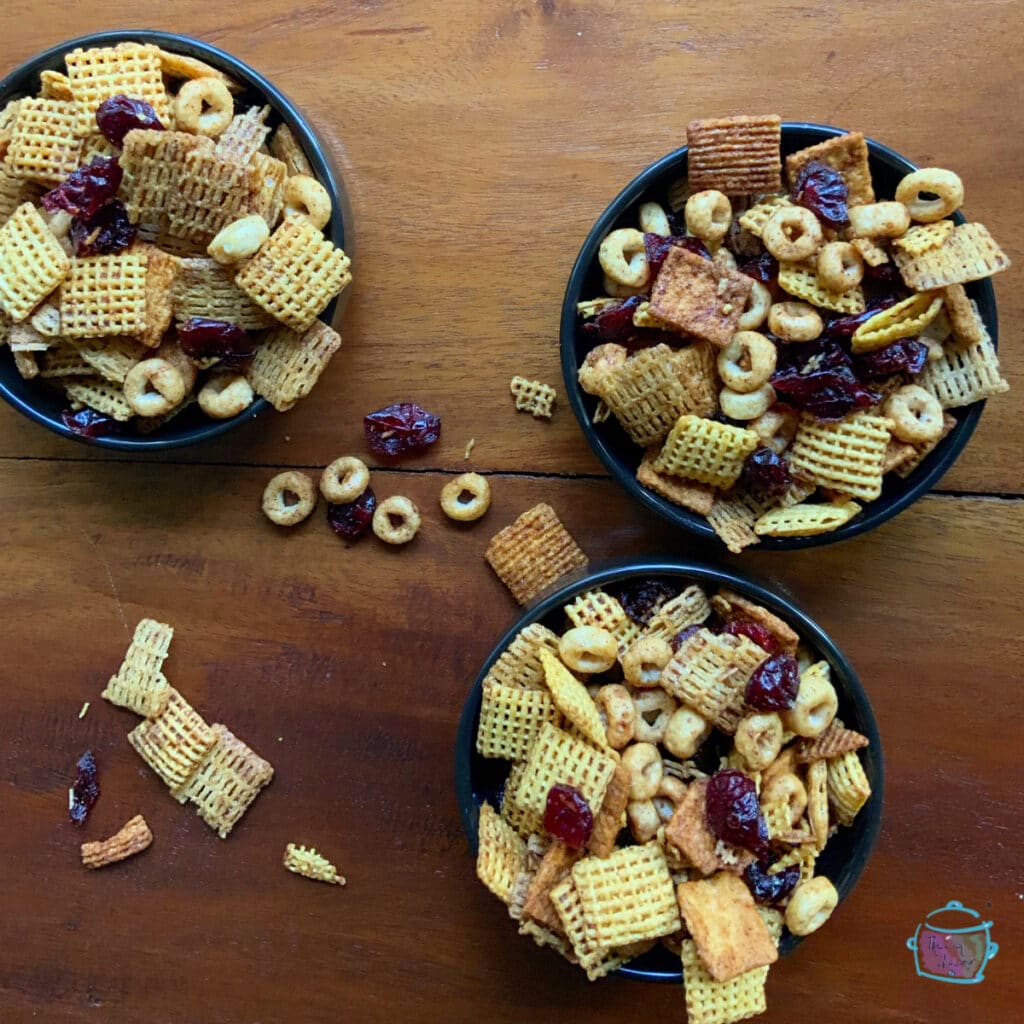 Three bowls holding pumpkin pie snack mix