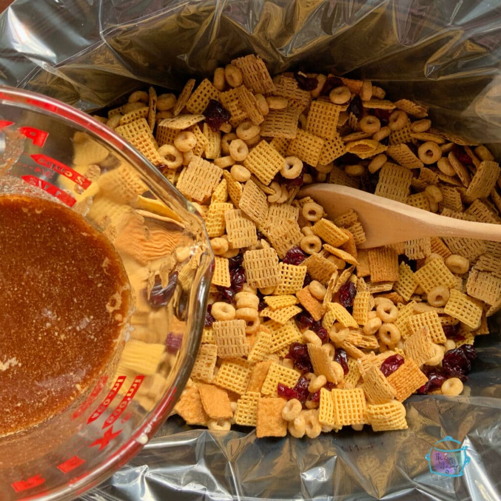 Pouring coating onto cereal mixture in slow cooker