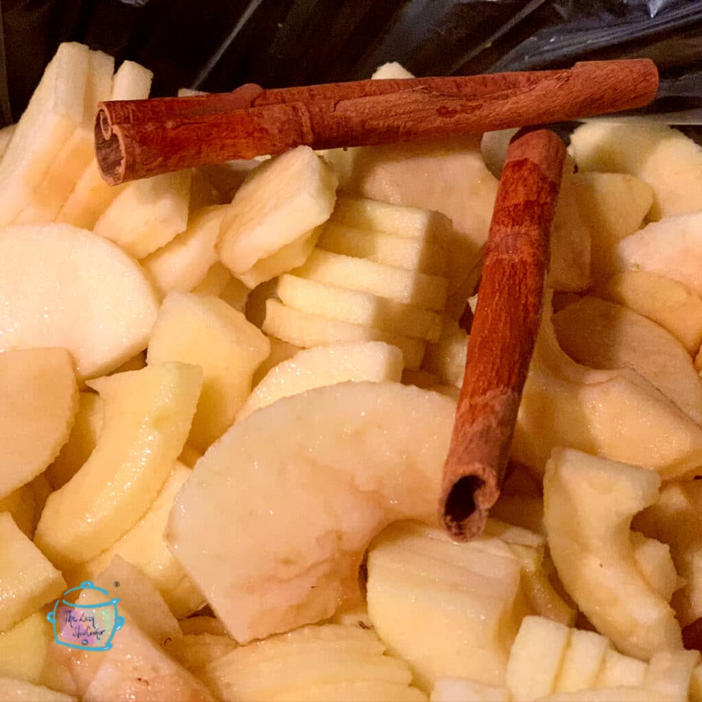 Apple chunks in slow cooker with cinnamon sticks