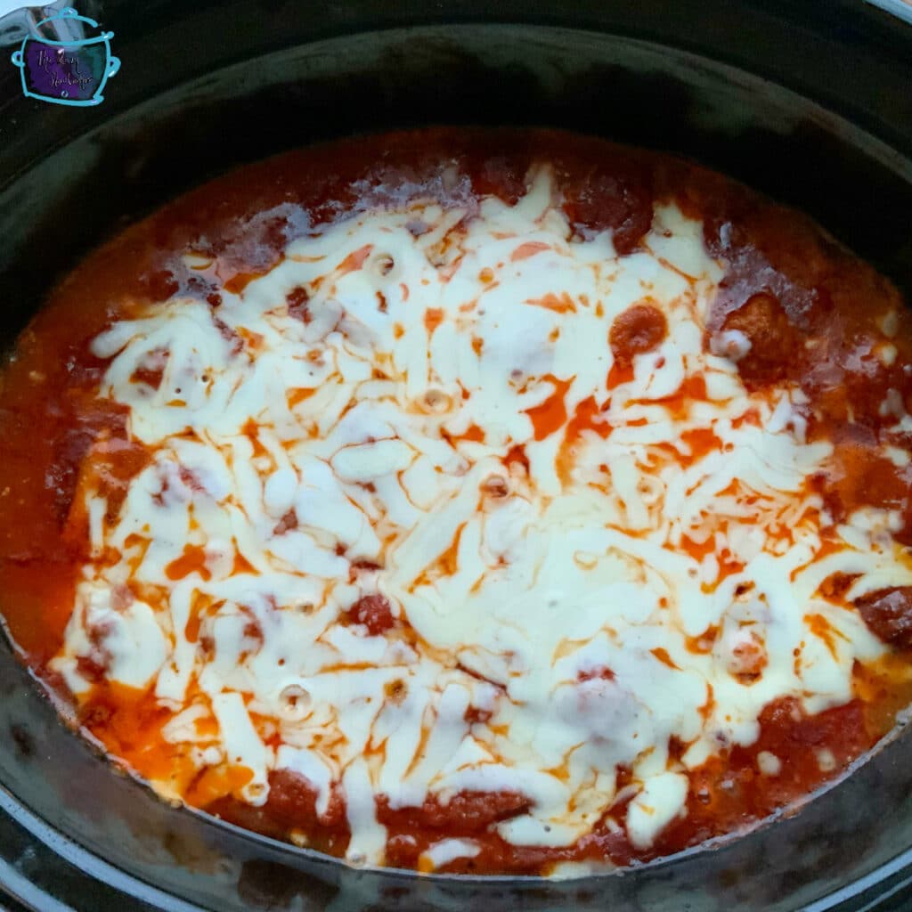 Cheesy meatballs in slow cooker with melted top layer of cheese
