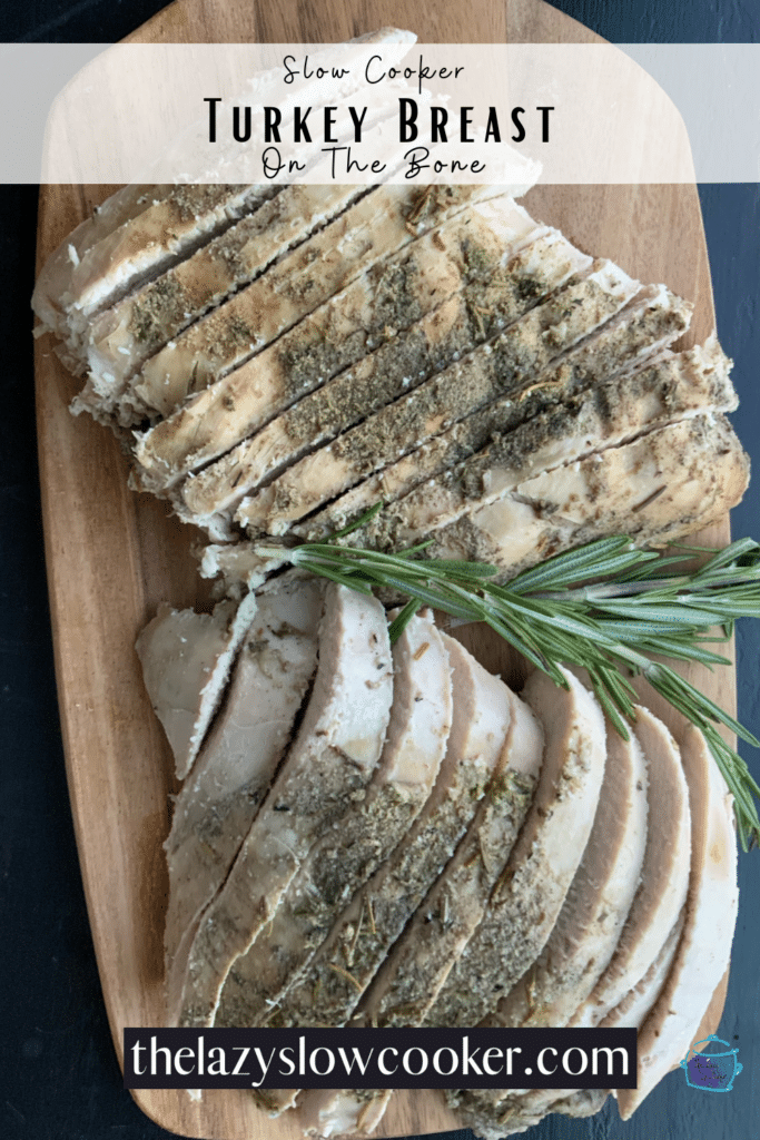 Turkey breast sliced and ready to serve with a fresh rosemary branch on top.