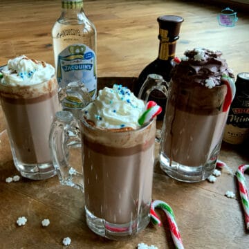 Three mugs of hot chocolate topped with whipped cream
