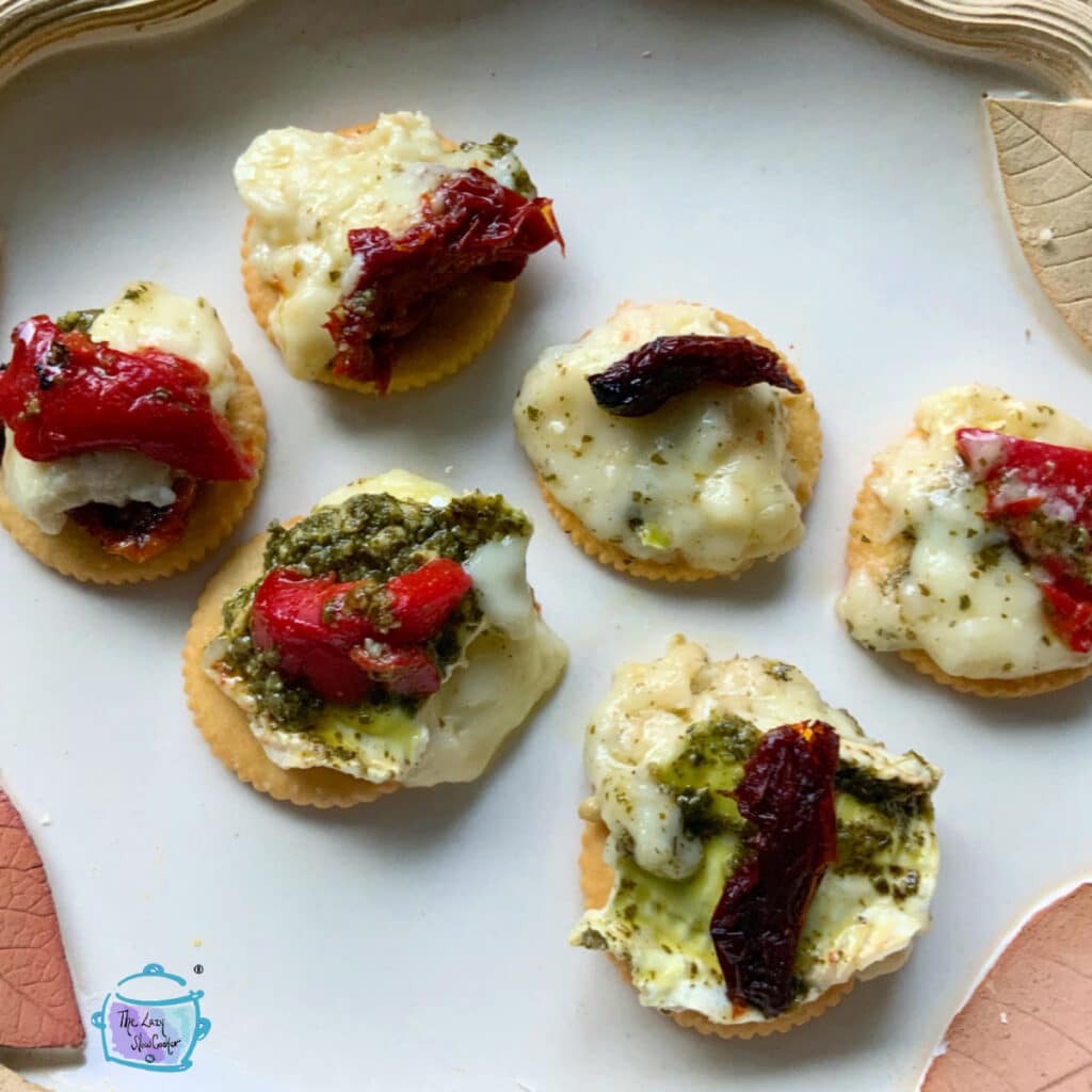 6 crackers with melted brie, pesto and either sun dried tomato or pepper piece
