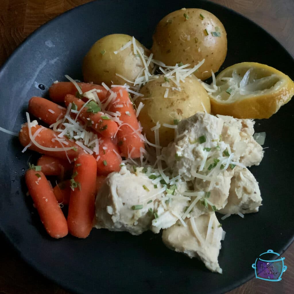 Crockpot lemon pepper chicken with veggies on a black plate