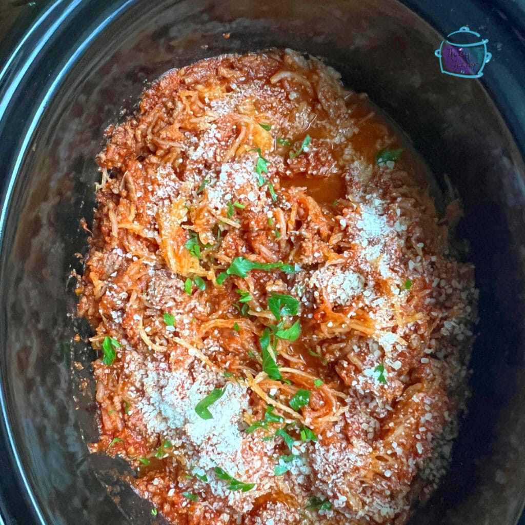 Spaghetti squash mixed with meat sauce and topped with cheese ready to serve