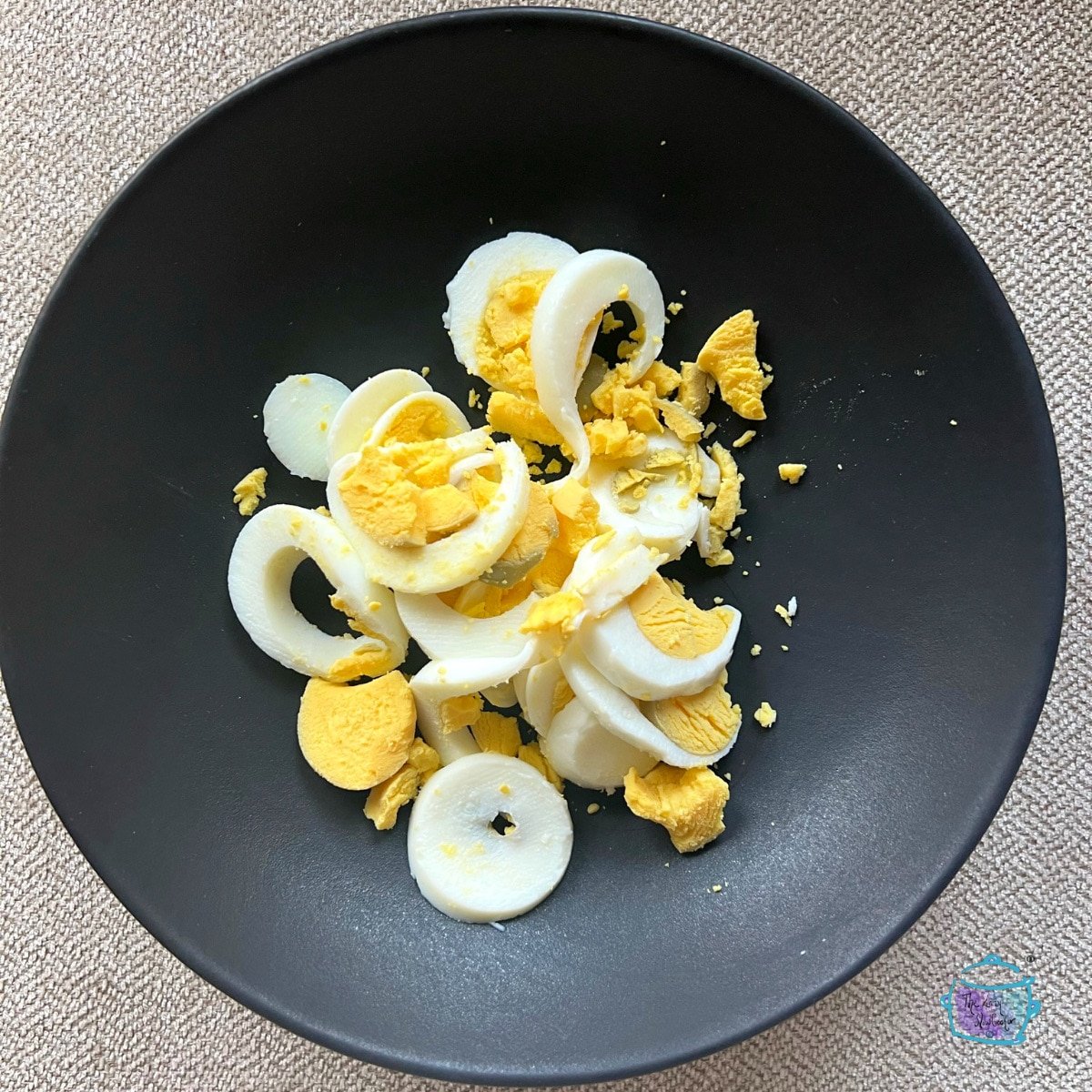 sliced hard boiled egg on a blac plate