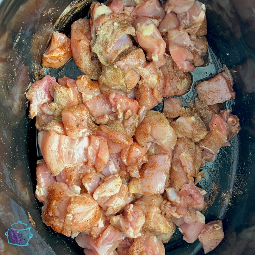 Chicken pieces in slow cooker tossed with all spices