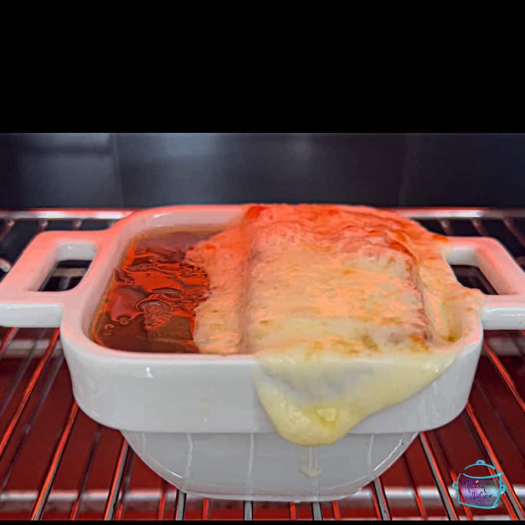a bowl of crockpot onion soup under the broiler