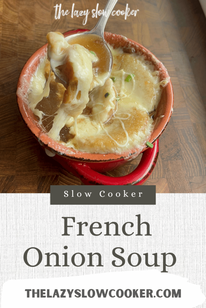 Slow cooker French onion soup in a red bowl with melted cheese stretched up on a spoon