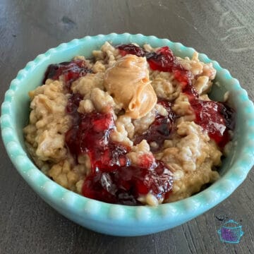 slow cooker oatmeal topped with a dollop of peanut butter and a swirl of jelly
