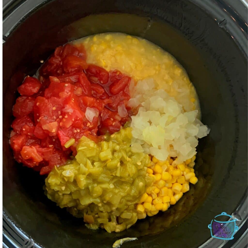 some raw fiesta dip ingredients in a slow cooker before mixing